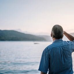 Man looking out at lake.