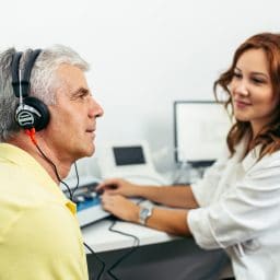 An older man receives a hearing test.