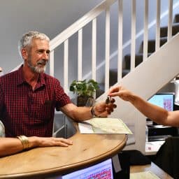 A Caucasion couple checking in a reception being friendly with the receptionist. They are getting the room key from her.