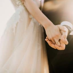 bride and groom hold hands