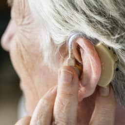 Woman touches hearing aid